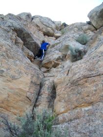 A kid climbing a cliff band
